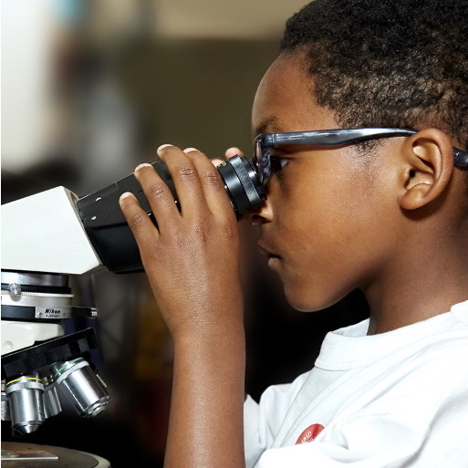 a young boy looking through a microscope