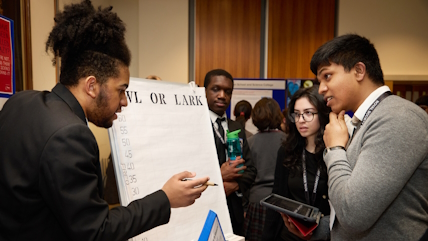 Partnership Grant school students explaining their research to other students at the conference