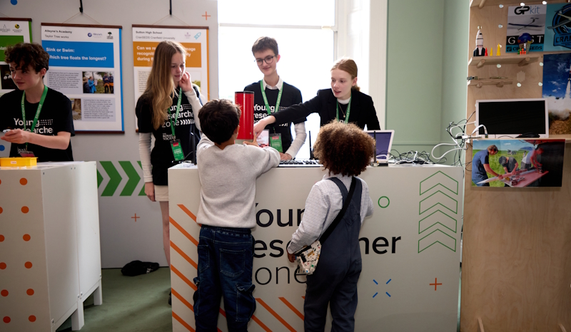 Partnership Grant students explaining their project to young visitors of the Summer Science Exhibition.