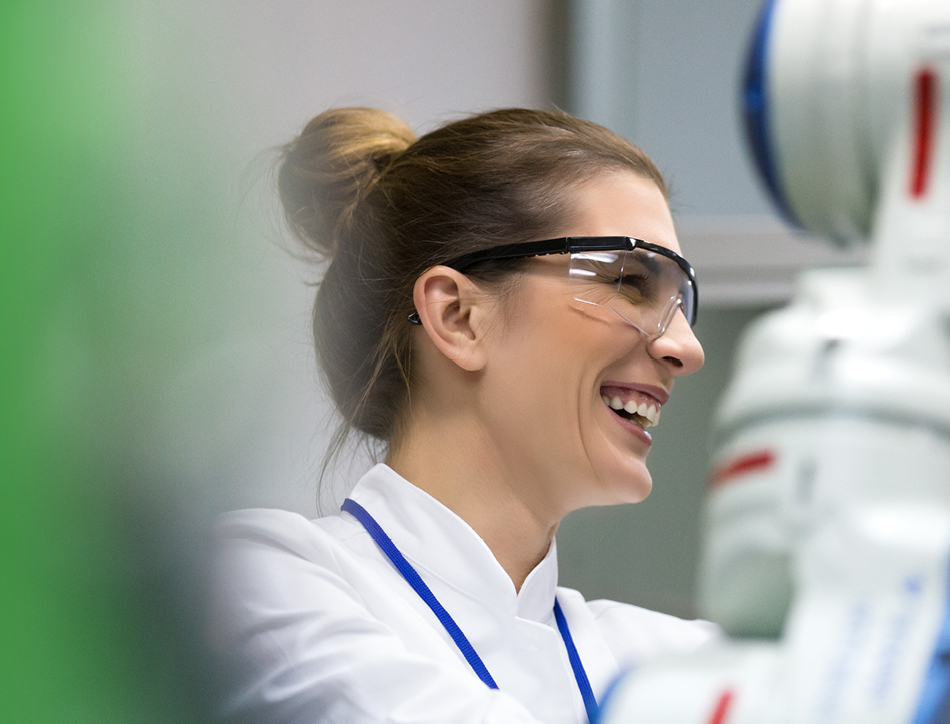 Young female scientist in safety goggles, smiling
