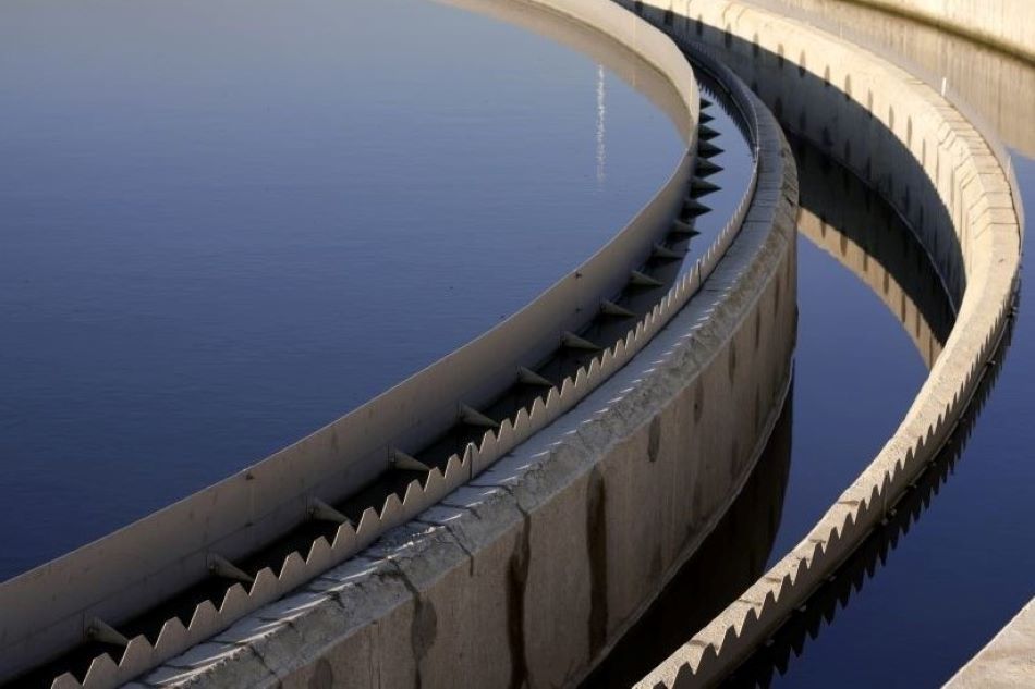 The curve of a large dam with dark blue water