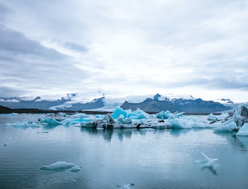 Melting icebergs with snow capped mountains