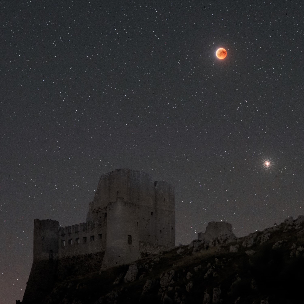 Castle ruins and an eclipsed Moon.