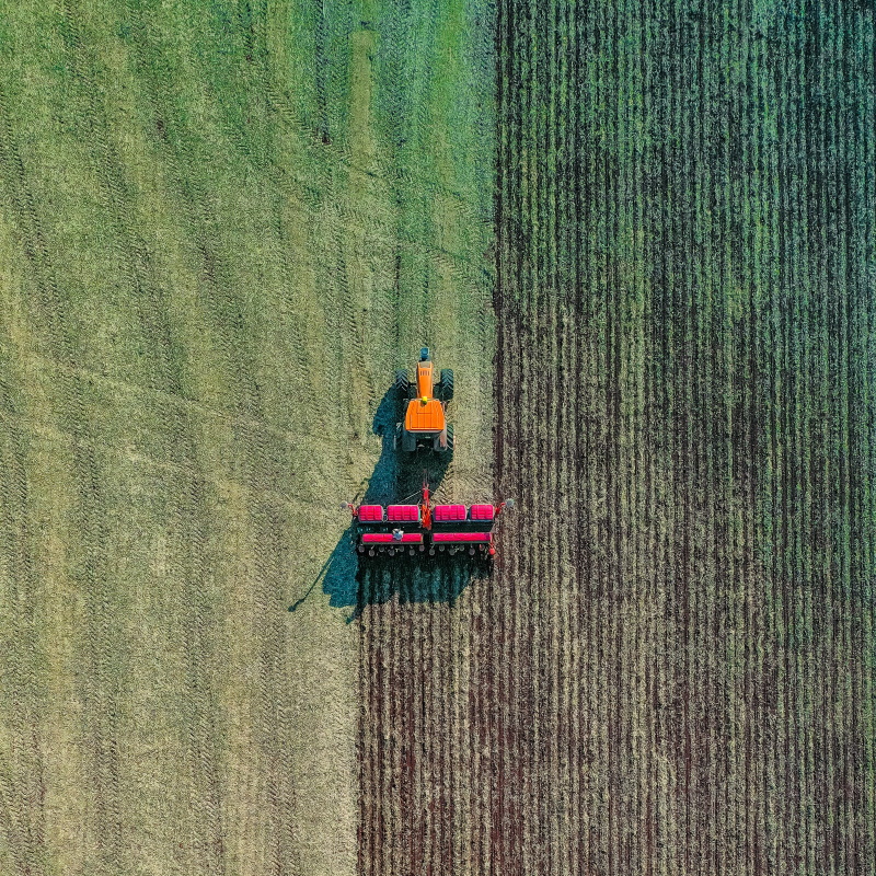aerial shot of tractor ploughing field