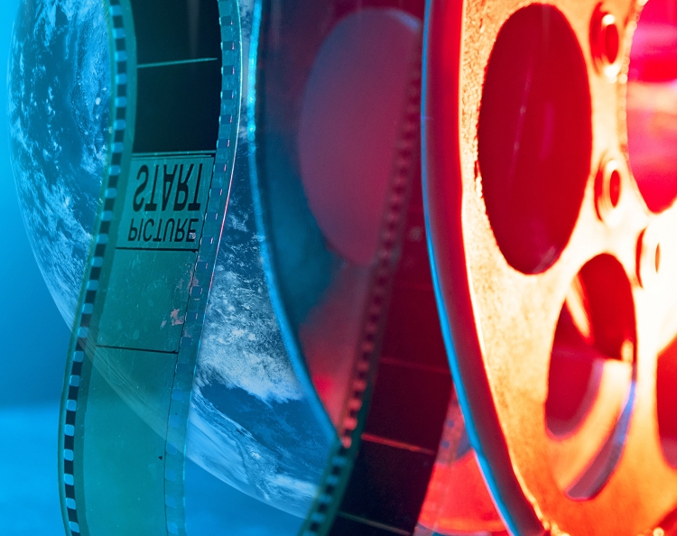Film canister unravelling against an image of the Earth from space