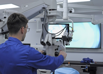 Doctor operating eye surgery machinery