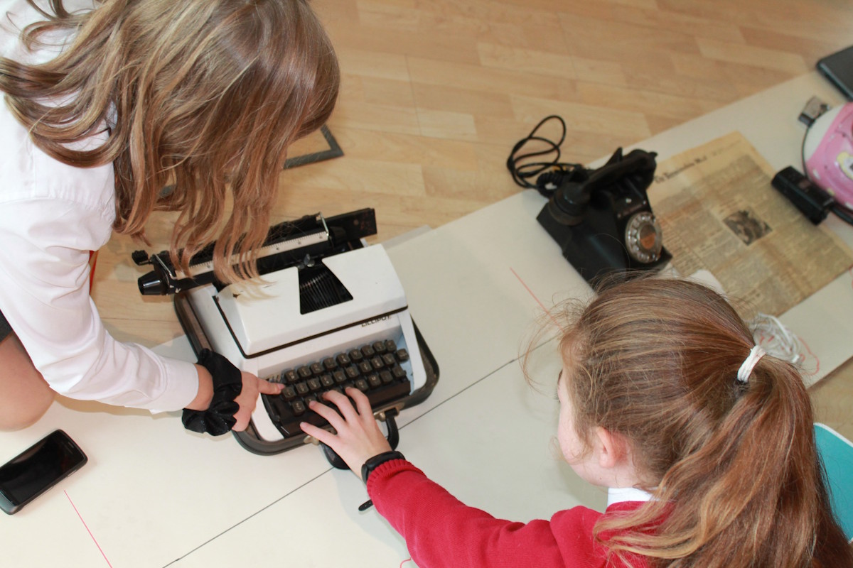 Children interacting with a typewriter.