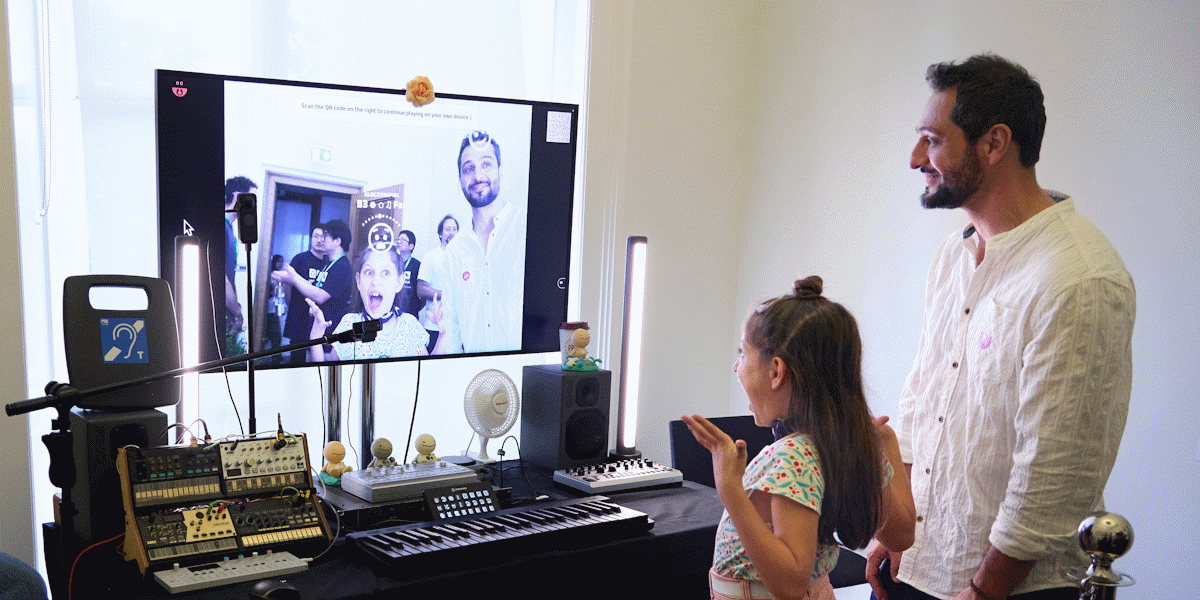 A child and adult making faces at the PhotoSYNTH to make music